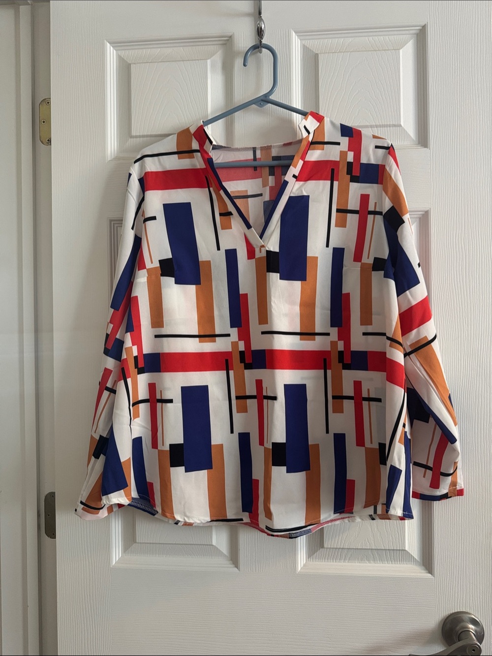 Geometric Print V-Neck Women’s Blouse in White with Blue, Orange and Tan Accents